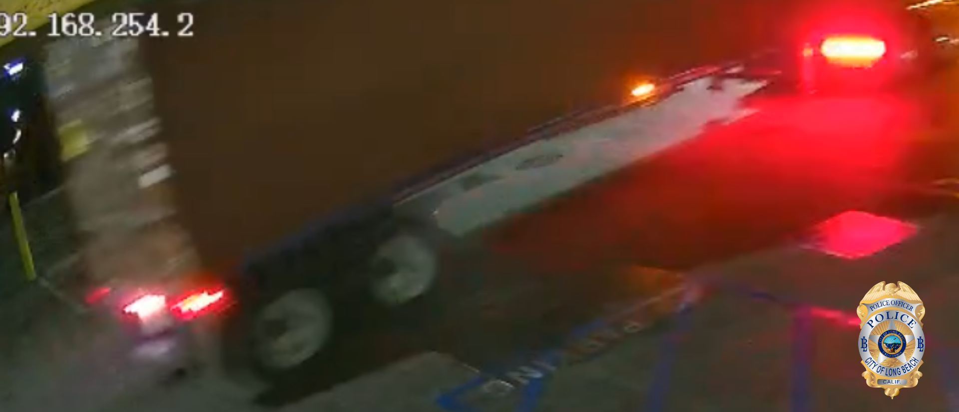 Blurry photo of the back end of a tractor-trailer rig at night.