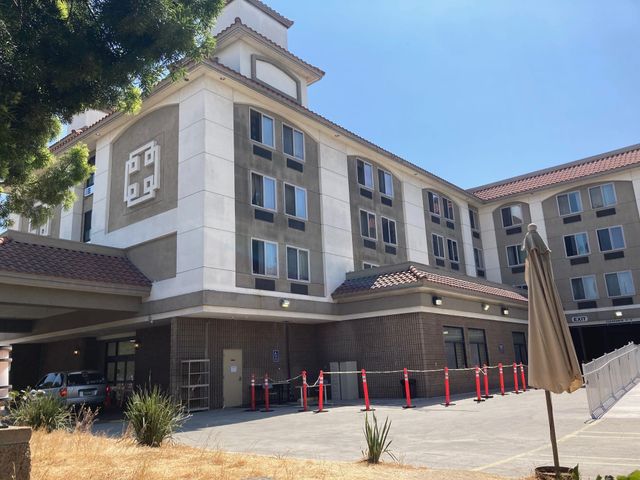 A four-story, beige, tile-roofe building that used to be a hotel is pictured.