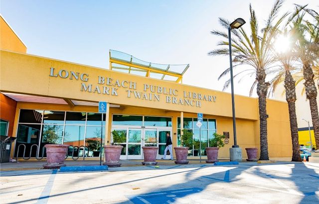 A yellow building with lots of windows that is labeled "Long Beach Public Library Mark Twain Branch."
