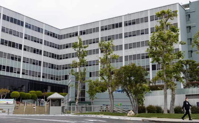 A person walks past a large building.
