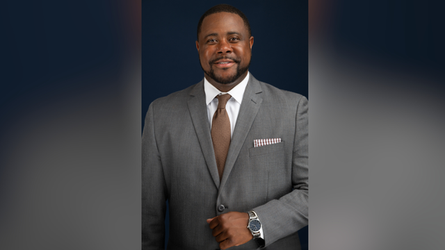 A distinguished man wears a coat and tie.