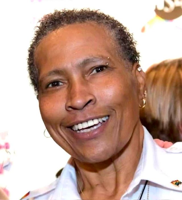 Closeup of a woman with short hair and a big smile.