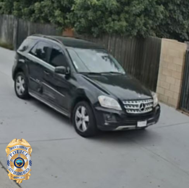 Surveillance camera photo of a black car with tinted windows and damage on the right passenger doors.