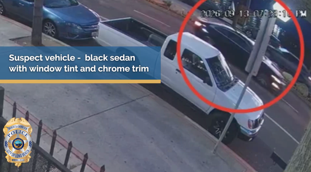 A black car with a red circle around it is on a street driving by a white pickup truck and a blue car.