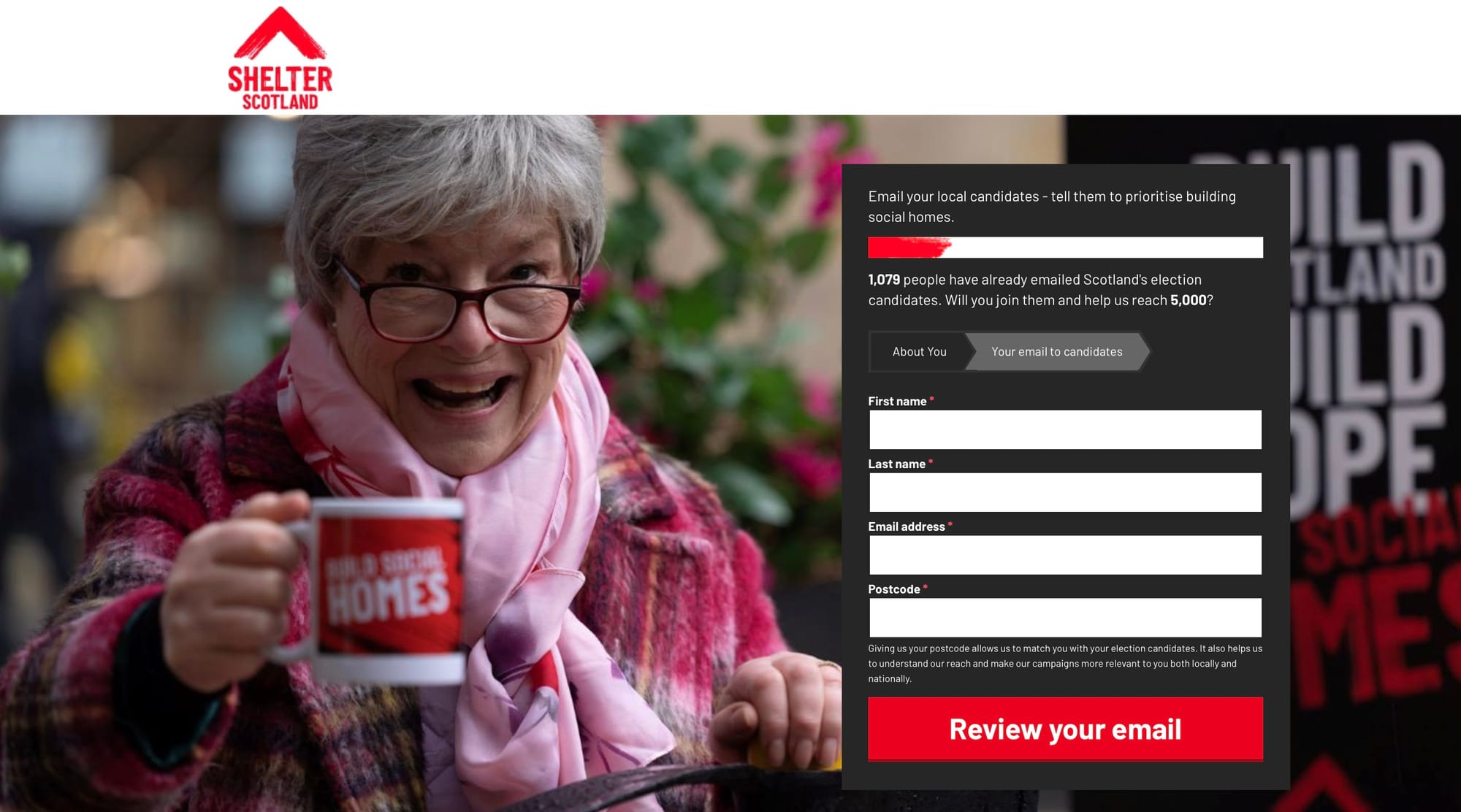 Older woman smiling and holding a mug with “Build social homes” text, alongside a campaign form encouraging people to email candidates about social housing in Scotland.