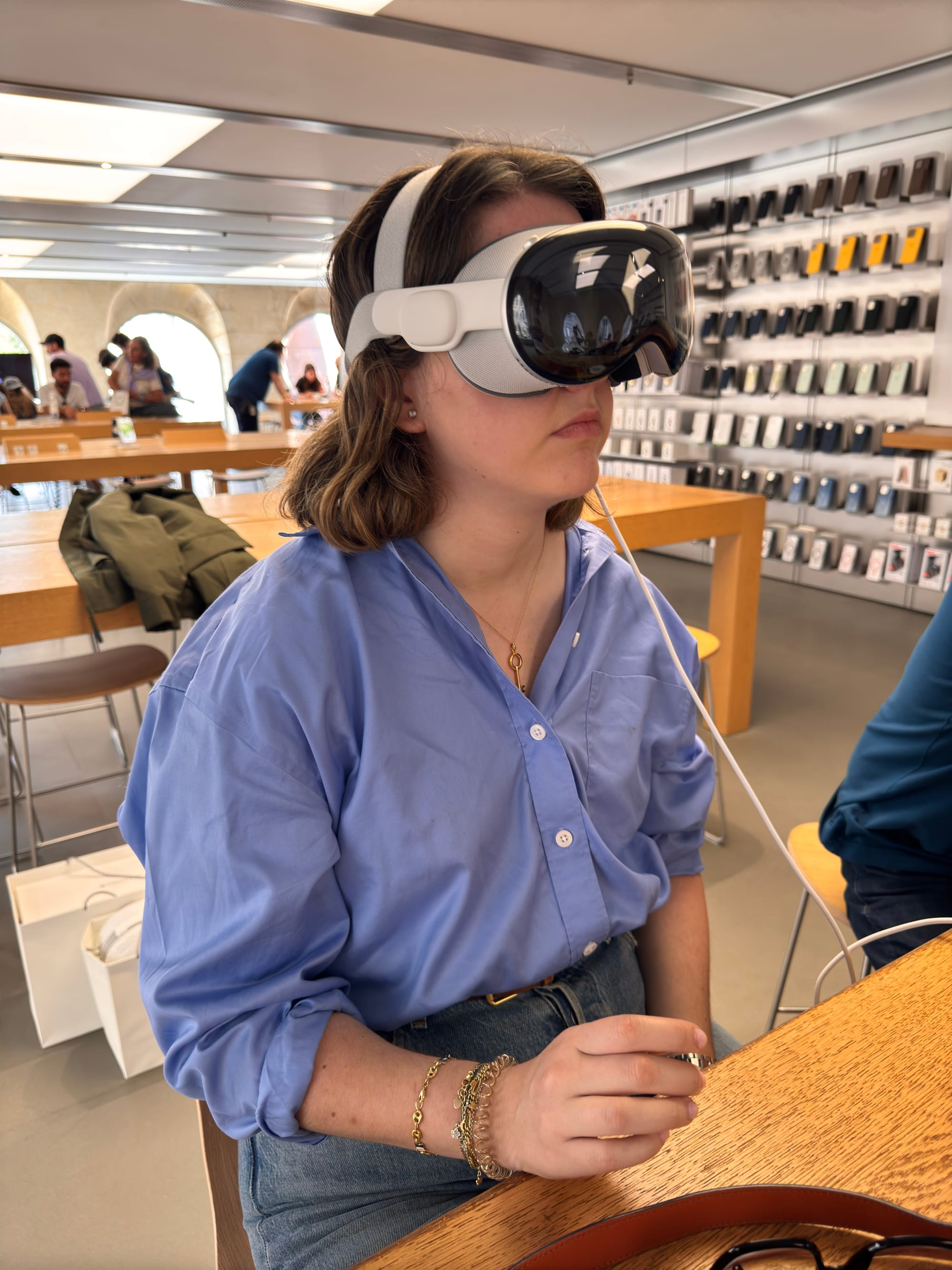 Patricia testing Vision Pro for the first time during a spontaneous trip to Bordeaux. Inside the Apple Store, immersed in the demo, surrounded by shelves full of devices and a quiet sense of excitement.