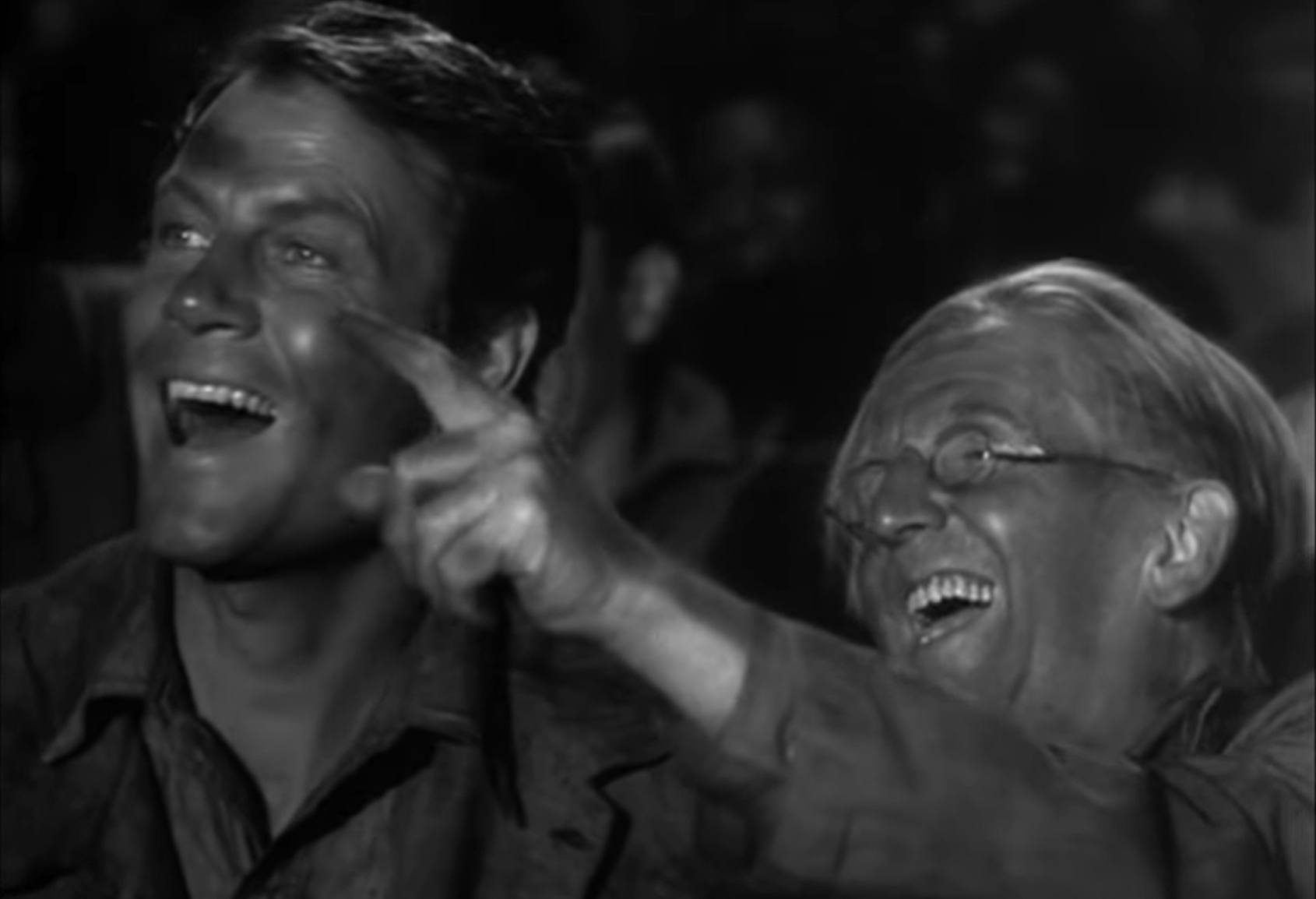 In a black and white film still from "Sullivan's Travels,", the actors Joel McCrea and Jimmy Conlin laugh