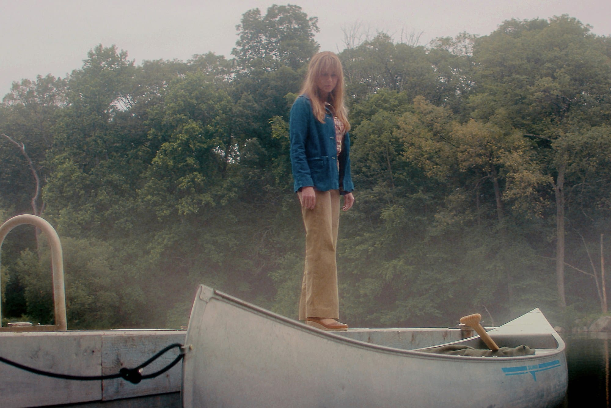 Szene aus der Serie Crystal Lake: eine Frau steht auf einem Boot am See