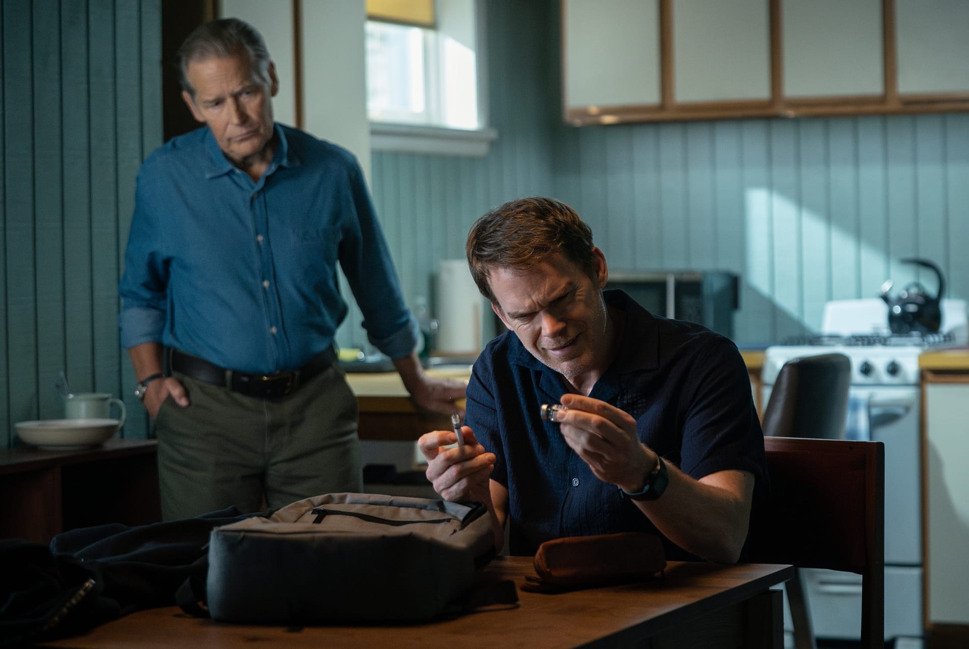 James Remar steht hinter Michael C. Hall, der am Küchentisch sitzt, Szene aus "Dexter: Wiedererwachen"