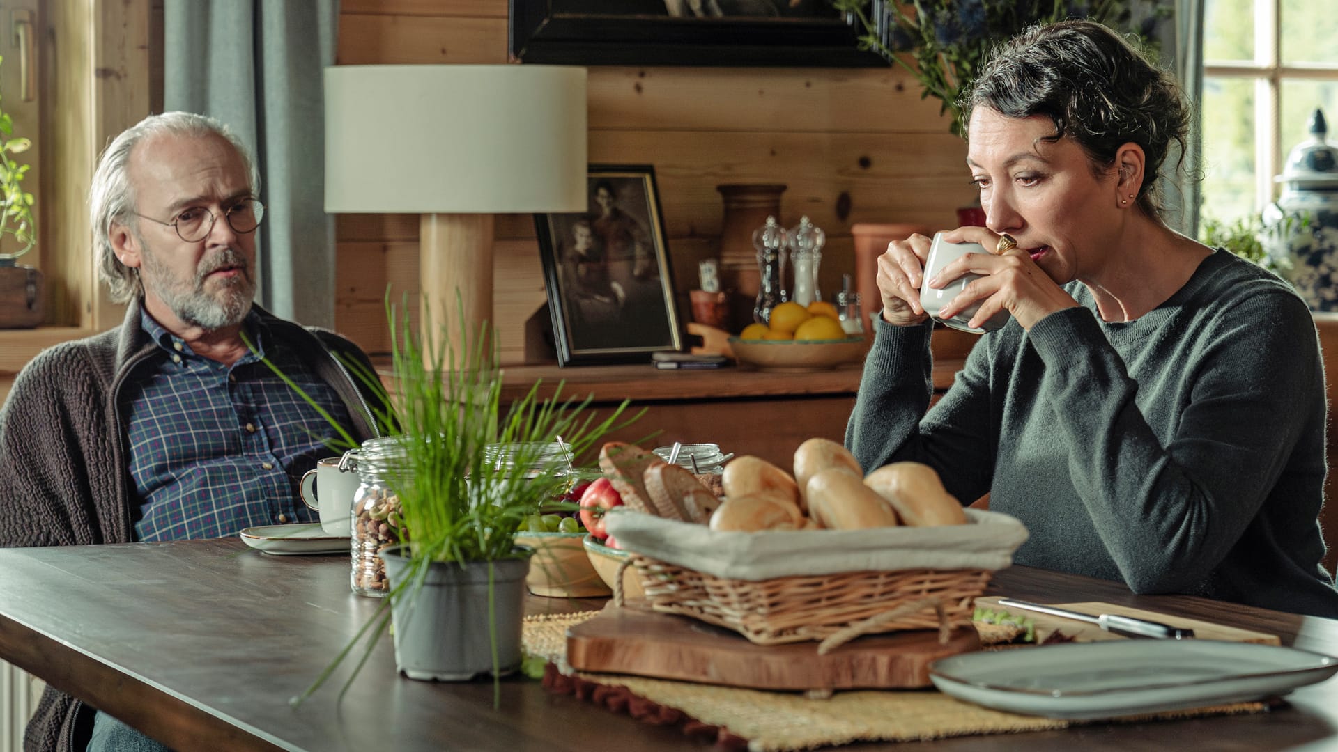 Ein älterer Mann und eine Frau mit Kaffeetasse am Frühstückstisch