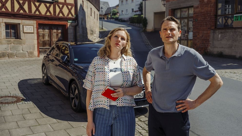 Rosalie Thomass und Fabian Hinrichs auf einer Dorfstraße in Gottesgarten