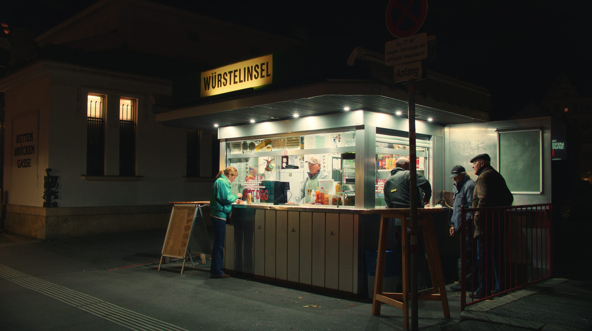 Nächtlicher Würstelstand in Wien mit einigen Gästen