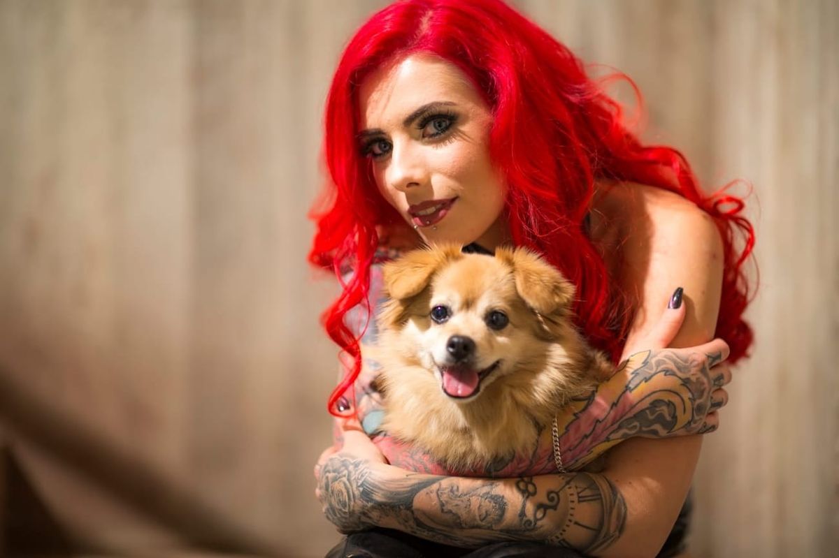Bonnie Stylez mit roten Haaren hält ihren Hund Flocke im Arm