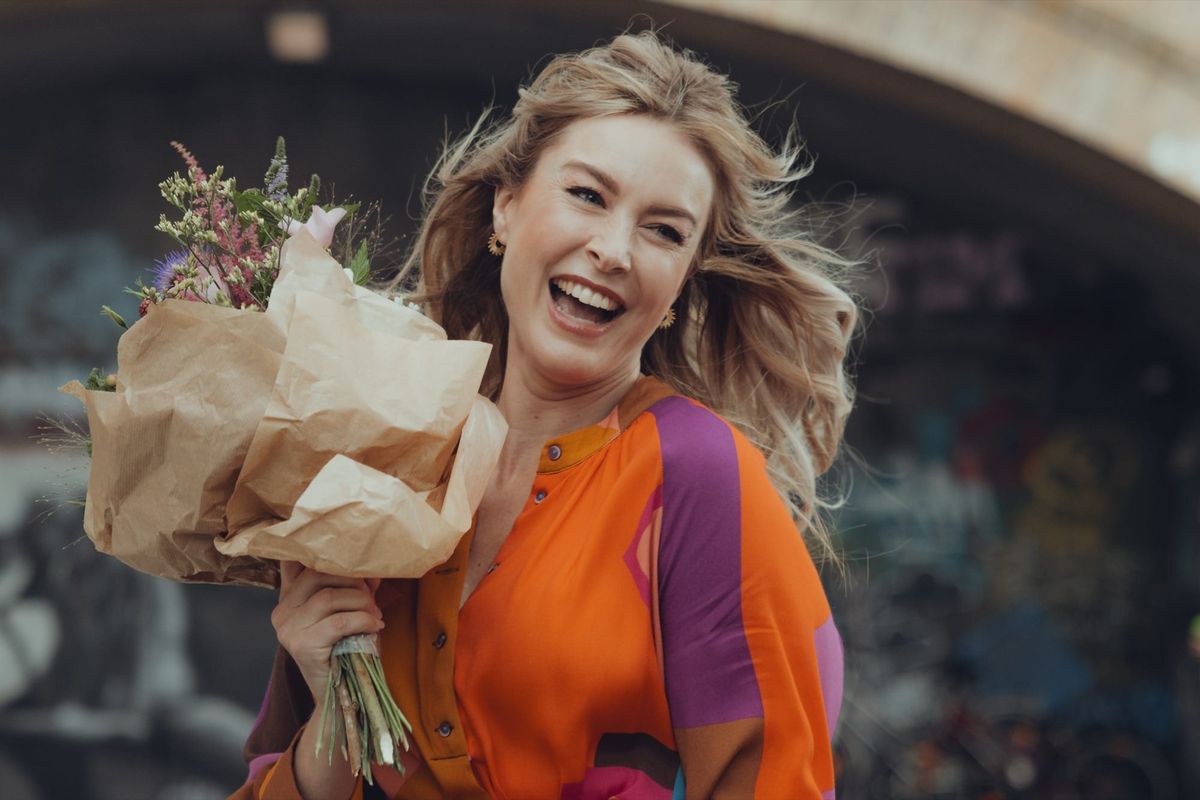 Nina Ensmann lacht mit einem Blumenstrauß im Arm