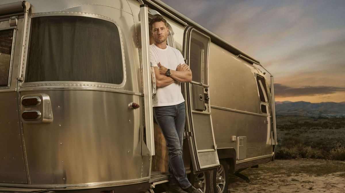 Justin Hartley als Colter Shaw in der Serie Tracker, lehnt mit verschränkten Armen in der Tür eines Wohnwagens