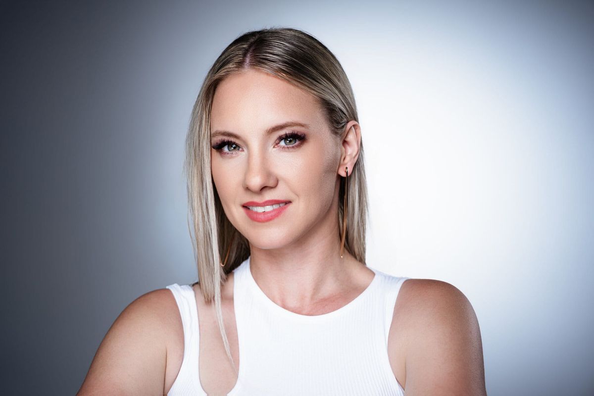 Charlien im weißen Top vor grauem Studiohintergrund