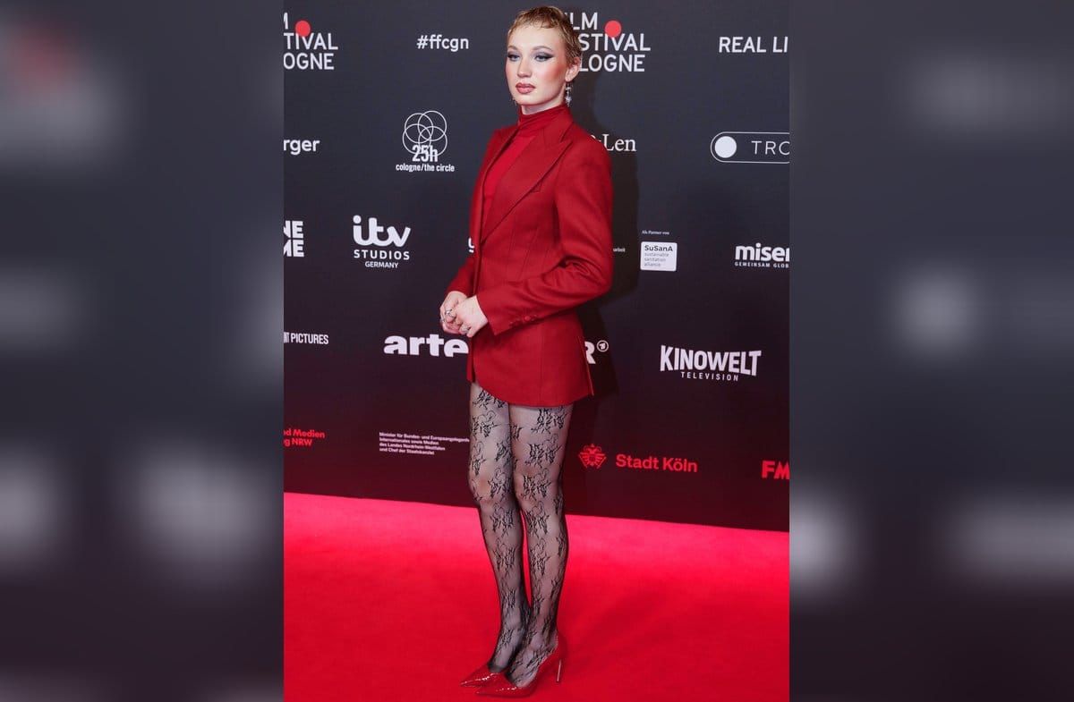 Helena Zengel in ihrem roten Komplett-Look mit schwarzer Spitzenstrumpfhose.