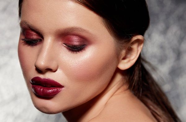 Weinrote Lippen unterstreichen das burgunderrote Augen-Make-up.