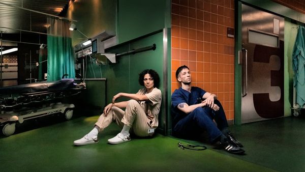 Haley Louise Jones und Slavko Popadić sitzen erschöpft auf dem Boden einer Notaufnahme in KRANK Berlin
