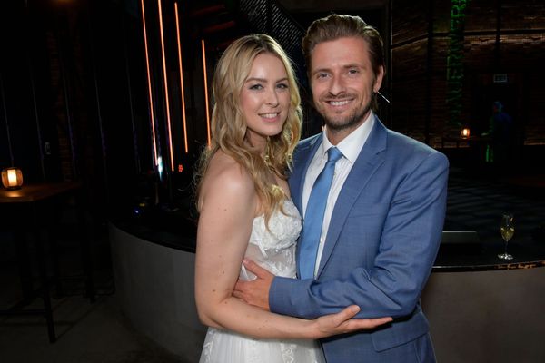 Jessica im Brautkleid und Philip im blauen Anzug umarmen sich