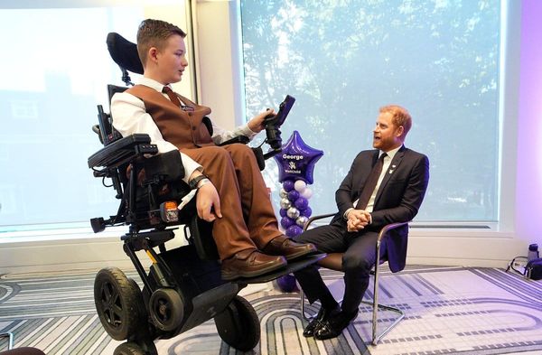 George, einer der jungen Gewinner, zeigt Harry seinen neuen Rollstuhl.