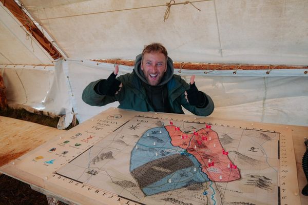 Torge Oelrich an einem Tisch mit der Spielkarte von Terrain