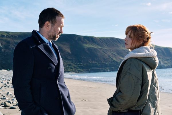 Rafe Spall und Kelly Reilly stehen sich an einem Strand gegenüber