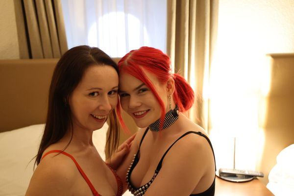Ronya Rabe und Mia May lächeln Wange an Wange in Dessous in einem Hotelzimmer