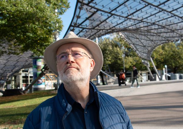 Harald Lesch mit Hut unter dem Zeltdach im Münchner Olympiapark