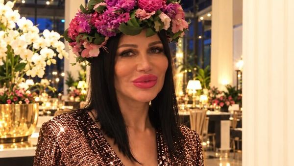 Djamila Rowe im Paillettenkleid mit Blumenkranz in einer festlich beleuchteten Halle