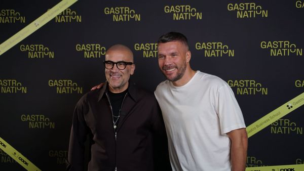 Kemal Üres und Lukas Podolski Arm in Arm vor der Gastronation-Pressewand in Hamburg