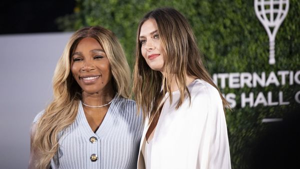 Serena Williams mit langen blonden Haaren und hellblauem Strickkleid lächelt neben Maria Sharapova in weißer Bluse