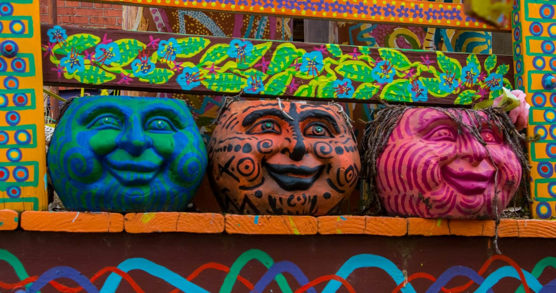 A group of colorful masks sitting on top of a window sill