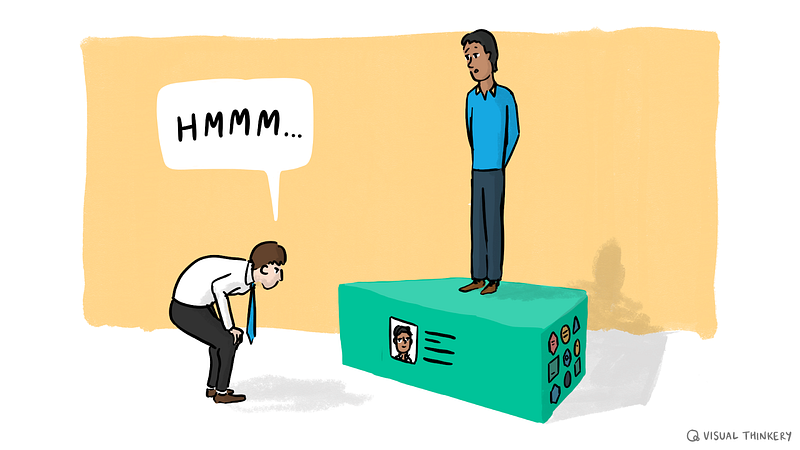 A person with shirt and tie saying “Hmmm…” while looking at one aspect of a ‘box’ on top of which someone else is standing. O