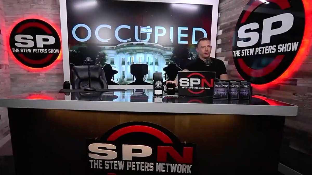 Stew Peters sitting at his desk as he promotes “Occupied” and his own show logo.
