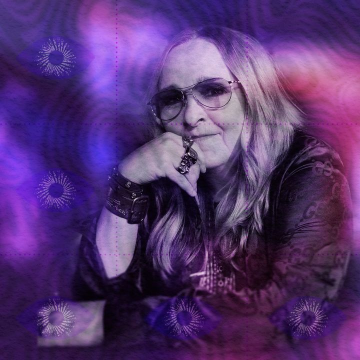 Portrait of Melissa Etheridge in aviator glasses, chin resting on her ringed hand, in a violet-and-magenta colour wash.