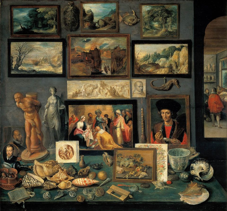 An oil painting of a "wonder cabinet" filled with many landscape paintings, shells, statues and portraits. 