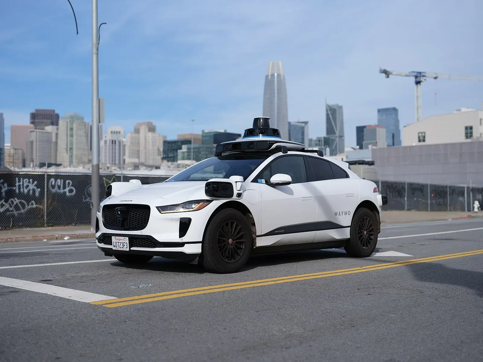 En vit Waymo-bil av modell Jaguar I-Pace kör på en gata i San Francisco utan någon i förarsätet