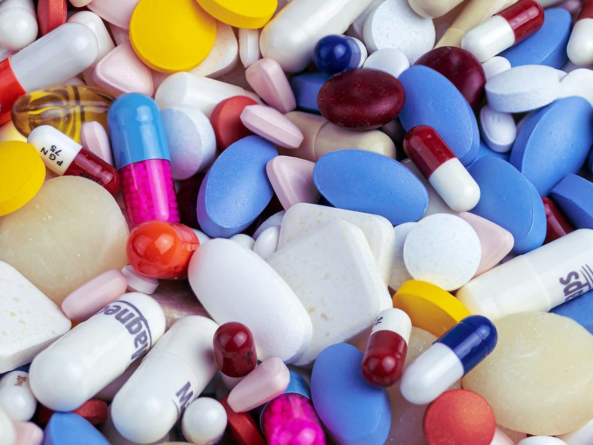 White, blue and orange medicine pills on a surface