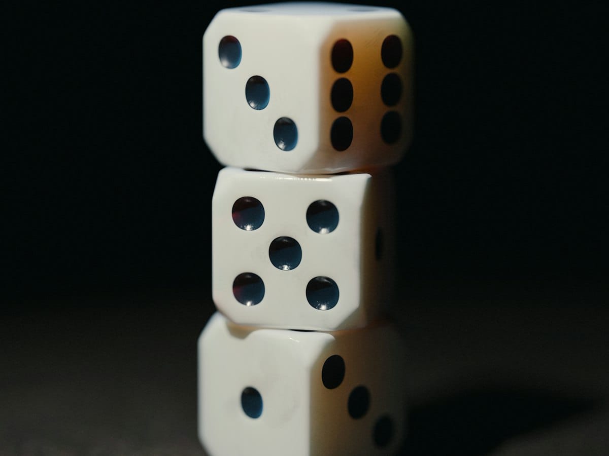 Three white dice stacked against a dark background