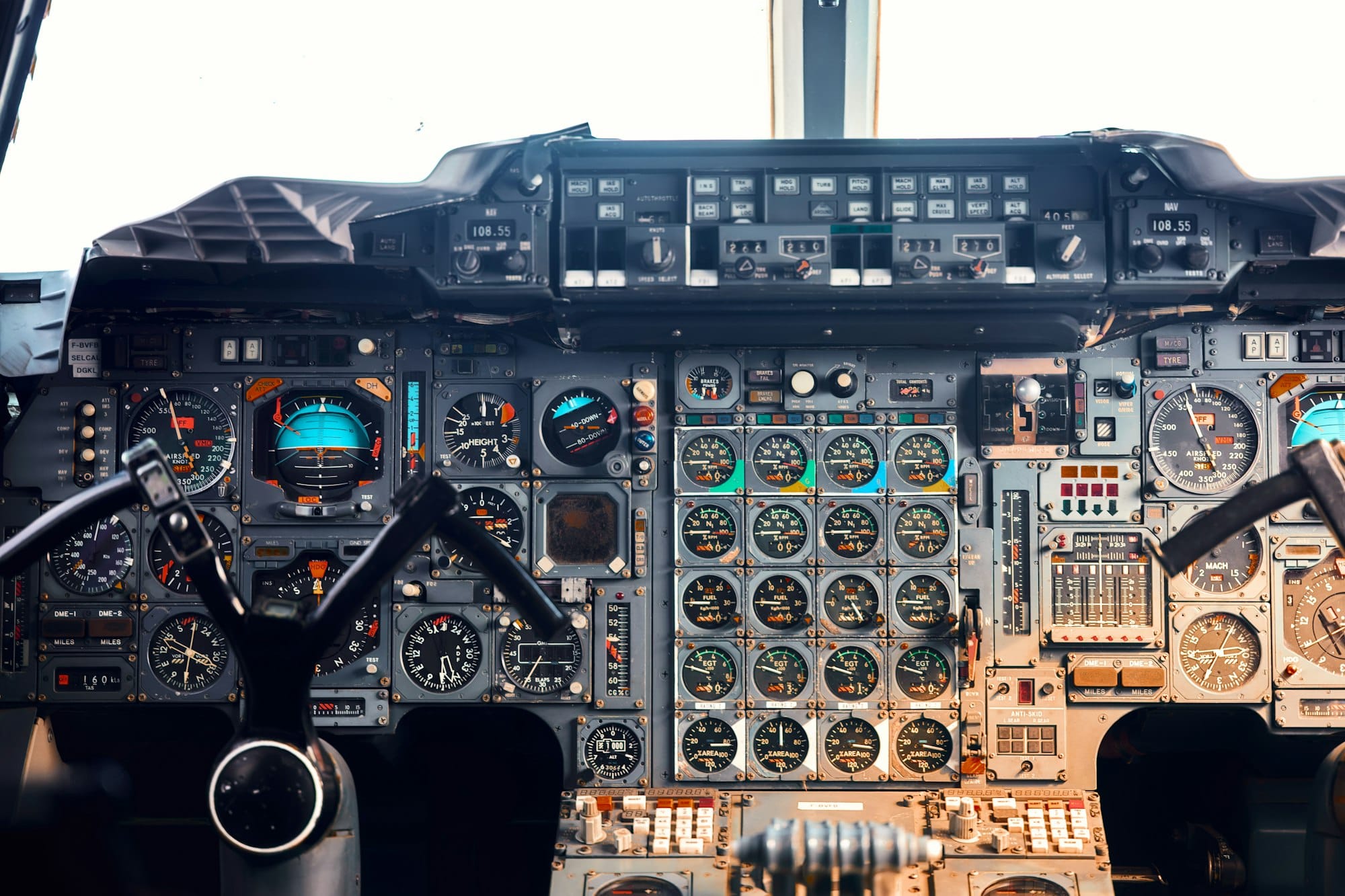 Close view of an aircraft cockpit instrument panel with round analog gauges