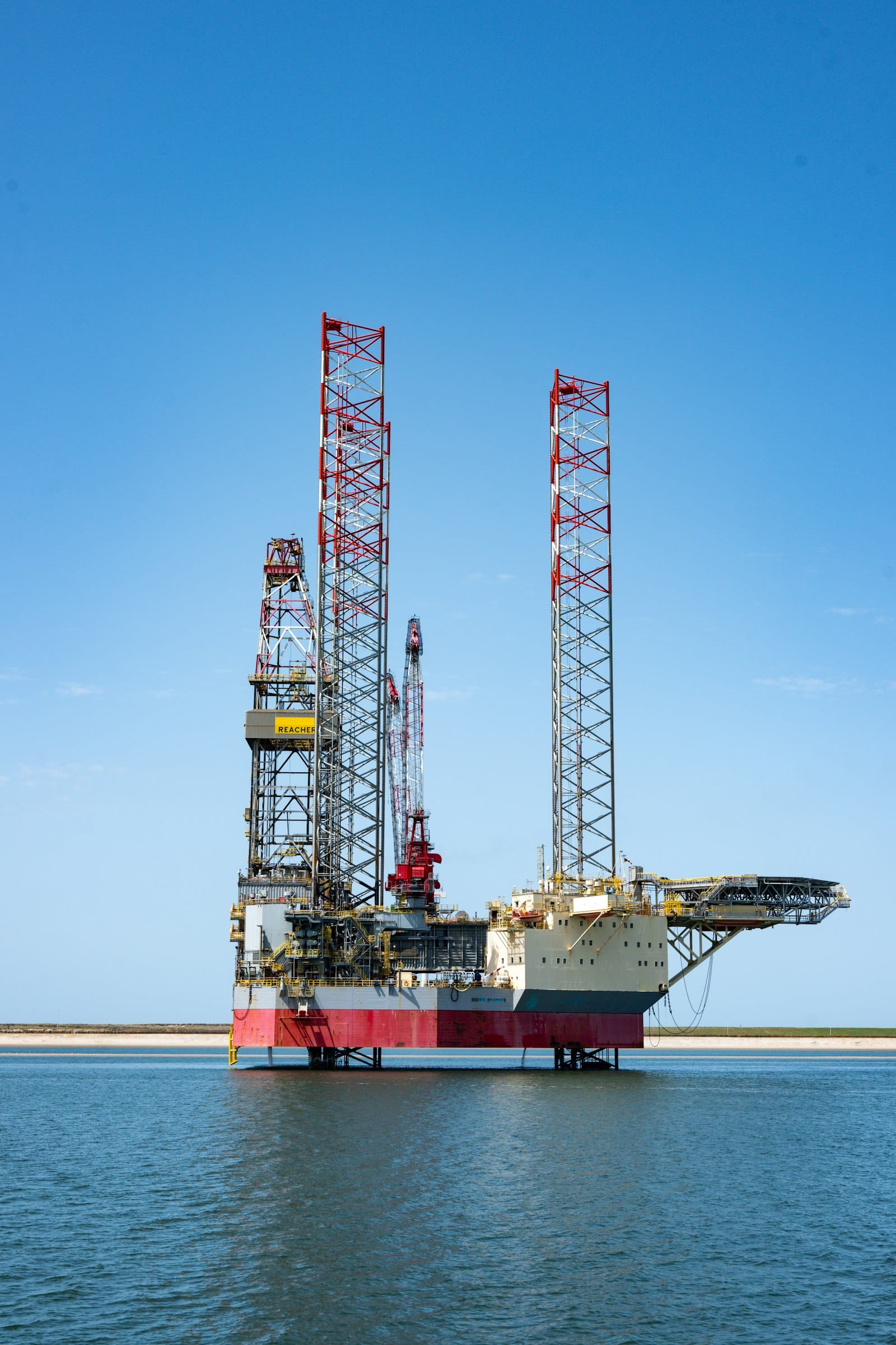 An offshore oil rig standing in calm blue water