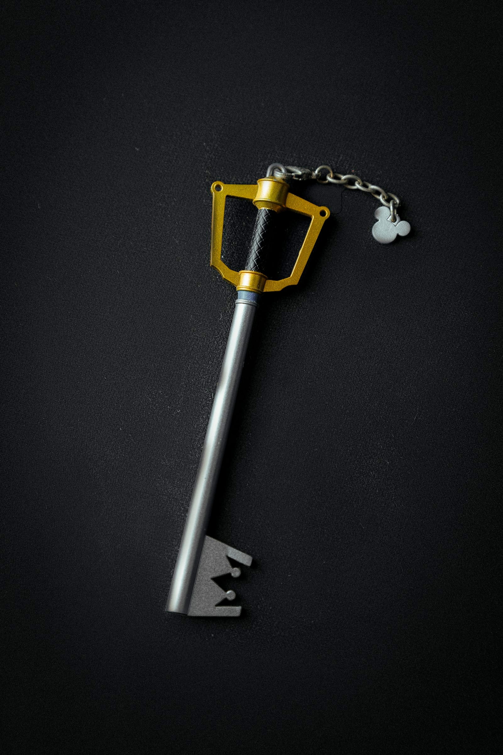 A set of silver keys on a key ring against a dark background