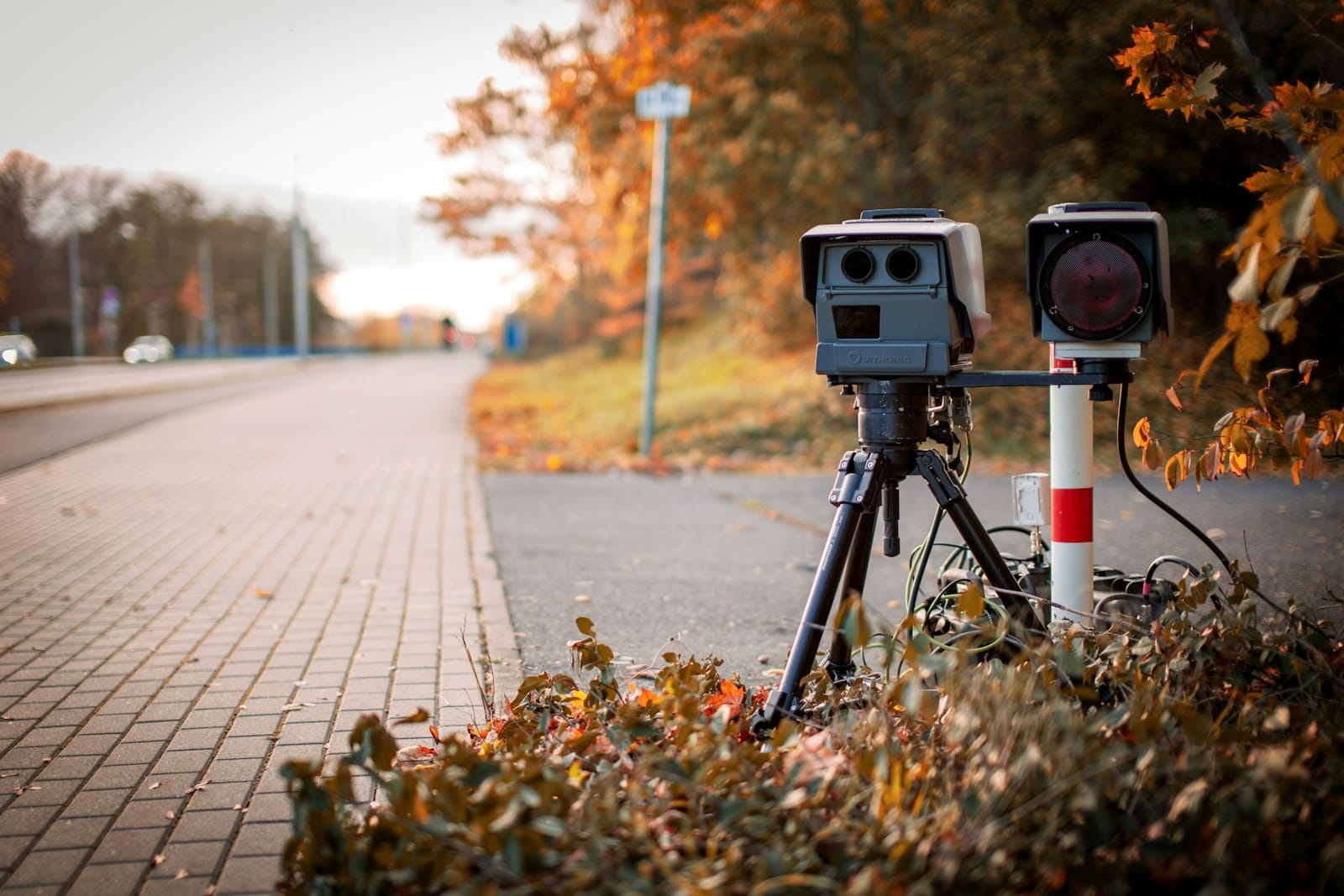 A camera on a tripod at the side of a road
