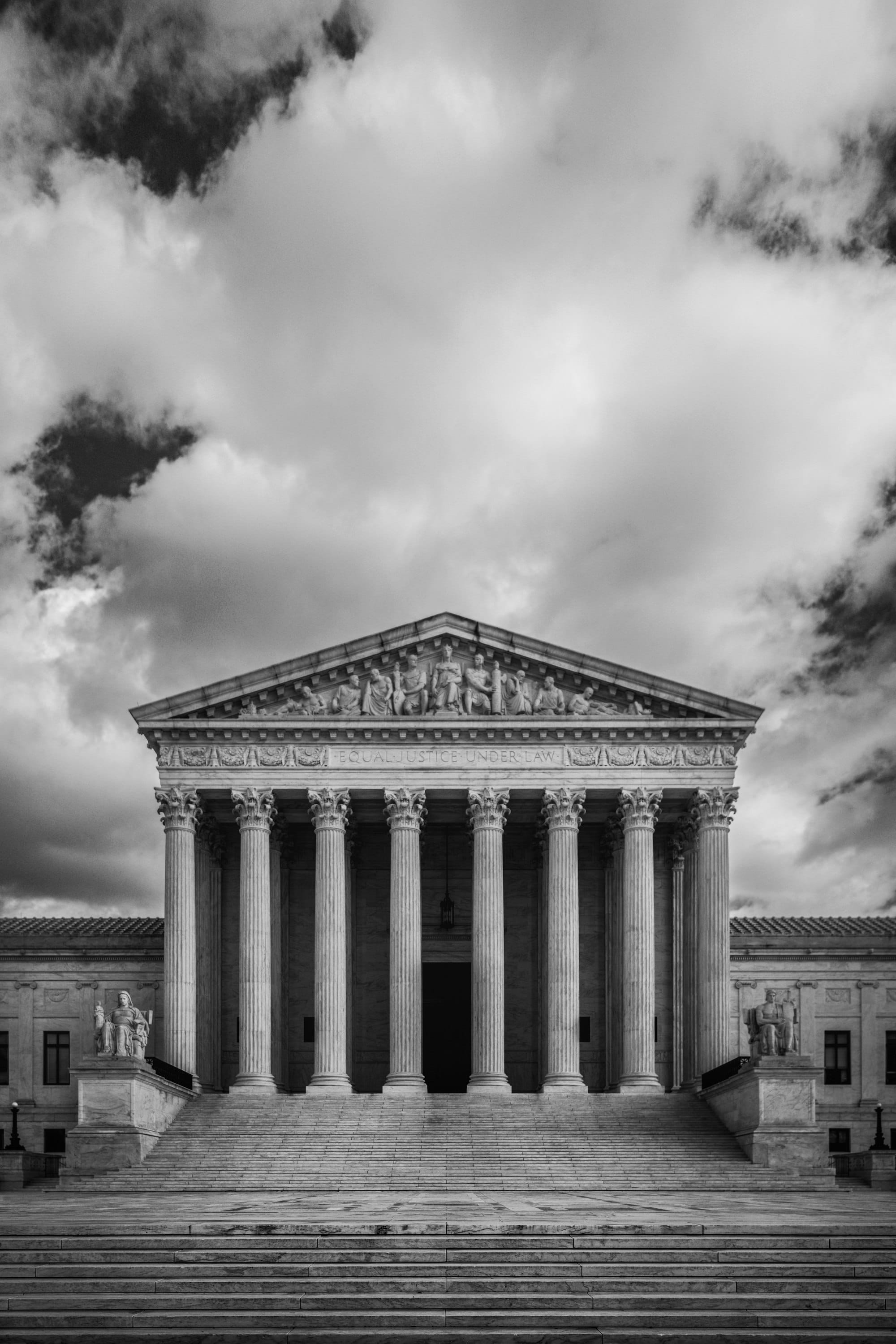 Black and white photograph of the front of the United States Supreme Court building with its columns