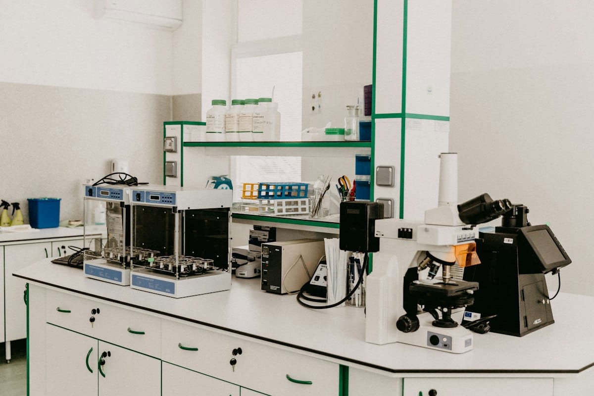A laboratory workbench with a microscope and analytical equipment in a bright room