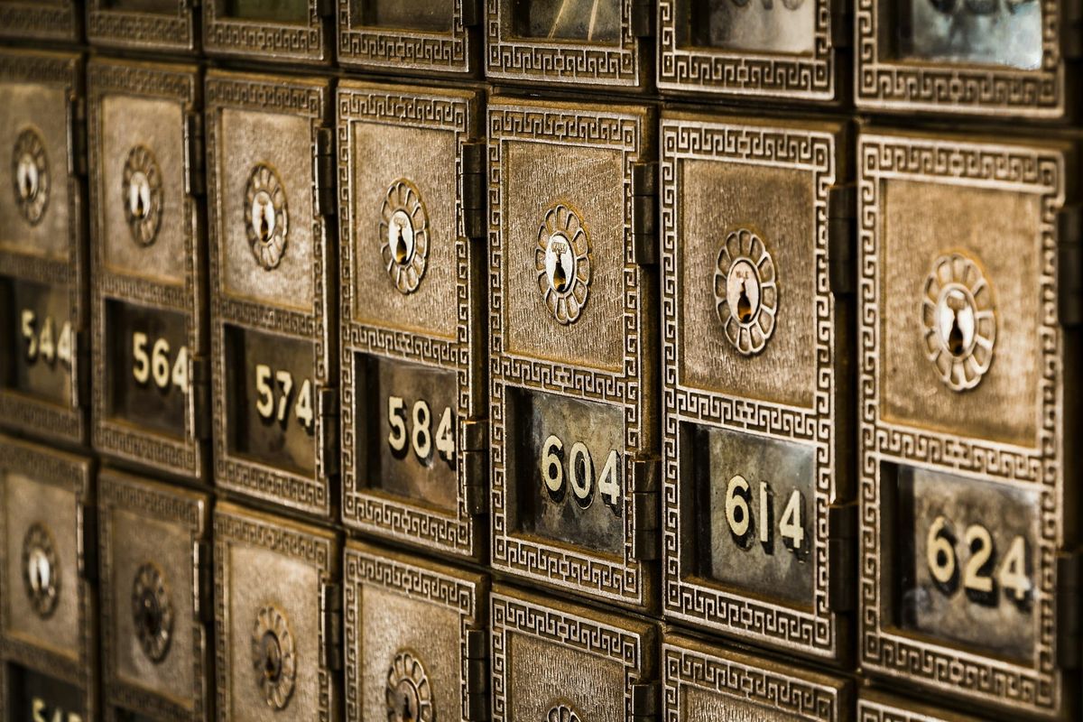 Rows of numbered metal safe deposit boxes in a bank