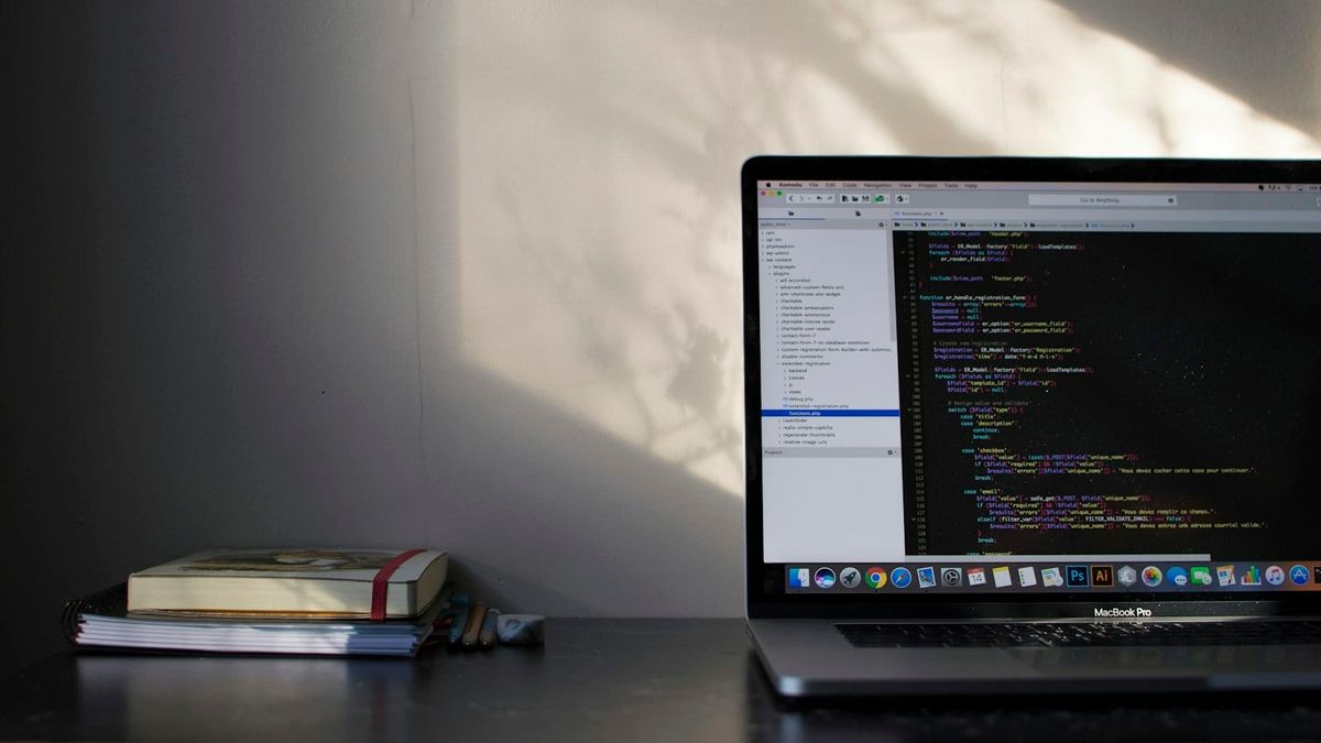 A laptop screen showing lines of code in a dark editor