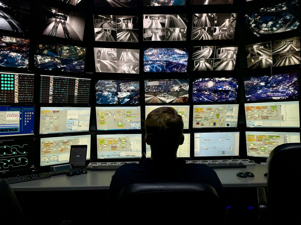 A man sitting in front of several computer monitors