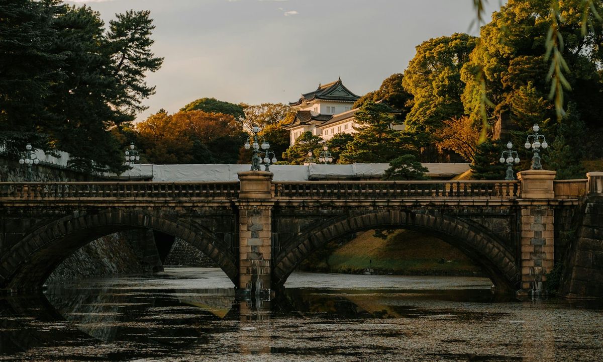 The Nijubashi stone bridge over the moat at the Imperial Palace in Tokyo, with a palace turret behind the trees
